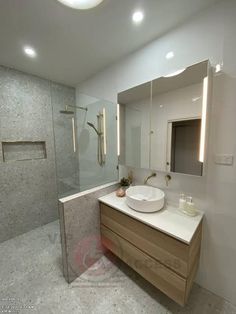 a bathroom with a sink, mirror and walk in shower