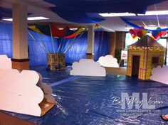 an indoor play area with blue tarp and balloons