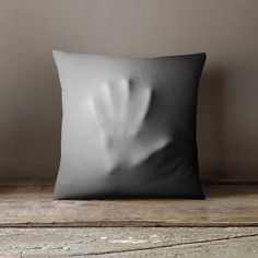 a black and white pillow sitting on top of a wooden floor