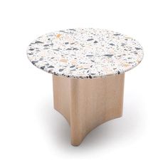 a round table with white and black speckles on the top, sitting in front of a white background