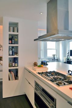 a kitchen with an oven, stove and shelves in the wall next to each other