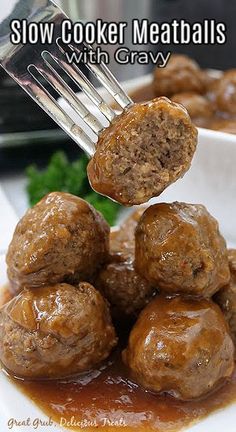 meatballs with gravy being lifted from a white plate by a fork over it