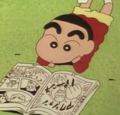 a cartoon character laying on the ground with an open book in front of him and reading it