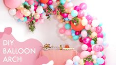 a table topped with lots of balloons next to a wall filled with cake and desserts