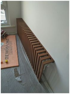 a wooden radiator sitting on top of a hard wood floor next to a window