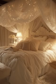 a white bed topped with lots of pillows under a canopy covered in sheer drapes