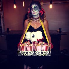 a woman dressed as a clown with cupcakes in front of her