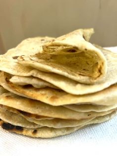 a stack of tortillas sitting on top of a white napkin