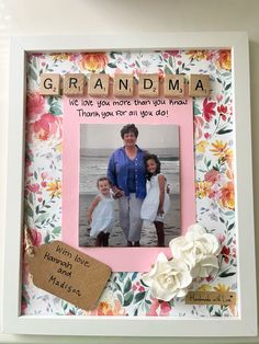 a family picture frame with flowers and scrabbles attached to it, which reads grandma we love you more than dad