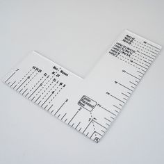 two rulers are laying next to each other on a white surface, one measuring the length