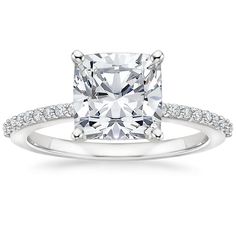 a cushion cut diamond engagement ring with pave set diamonds on the shoulders and sides