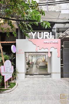 the entrance to yurh nail studio with pink and white paint dripping down it's walls