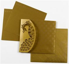 some gold colored paper with a peacock design on the front and bottom, along with brown envelopes