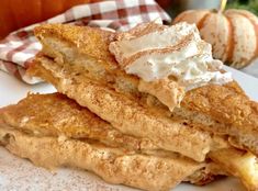 two pieces of french toast sitting on top of a white plate next to an apple