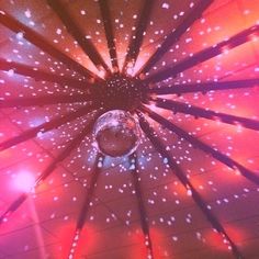 the inside of an umbrella is lit up with pink and white lights