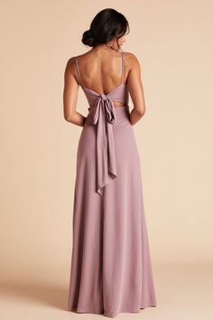 the back of a woman wearing a lavender colored dress with a bow at the waist