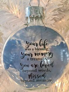 a glass ornament hanging on a christmas tree with the words you life was blessing your memory