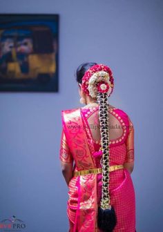 the back of a woman's head wearing a pink sari