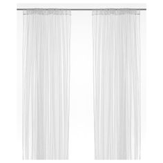 two white curtains hanging on a wall