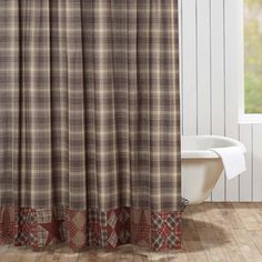 a bathroom with a bathtub, toilet and shower curtain in plaid pattern on the outside