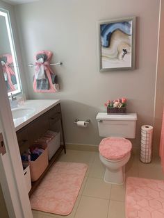 a bathroom with pink rugs on the floor and a white toilet in the corner