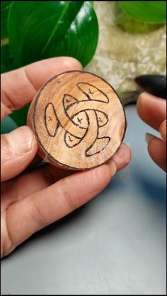 a person holding a piece of wood that has been carved into the shape of a knot