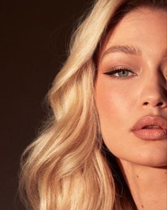 a woman with long blonde hair and blue eyeshadow is posing for the camera