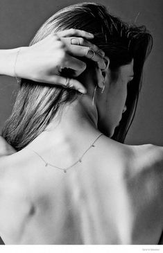 the back of a woman's neck with her hands on her shoulder