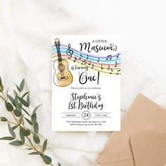 a little musical birthday party is on the table next to some envelopes and flowers