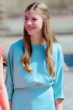 a girl in a blue dress smiles at the camera