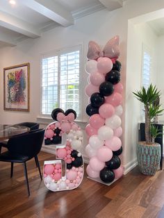 the balloon column is decorated with pink, black and white balloons