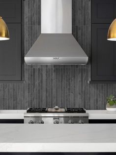 a stove top oven sitting inside of a kitchen next to two lights on the wall