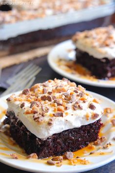 two white plates topped with brownies covered in frosting