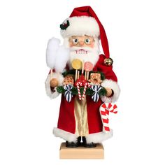 a santa clause figurine holding candy canes, candies and lollipops