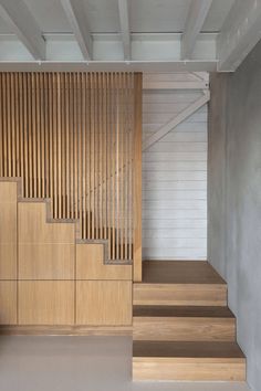 an empty room with wooden stairs and white walls