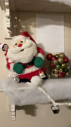 a santa clause sitting on top of a shelf