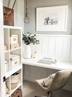 a white desk and chair in a small room with shelves on the wall above it