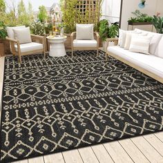 a black and white area rug on top of a wooden floor next to two couches