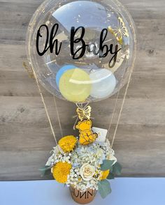 a vase filled with flowers and balloons sitting on top of a table