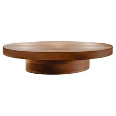 a round wooden table with an oval base on the top is shown in this image