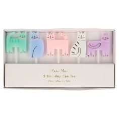 three birthday candles in a white box with animals on the front and one is pink, blue