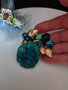 Beautiful brooch entirely handmade with a rough natural stone. To recreate a floral motif I used golden brass components, glass crystals and SW crystals. All in shades of teal and turquoise. Each item is solidly hand-stitched. The brooch from the back is finished with soft turquoise suede. The brooch is very bright and elegant. For those who love an unusual and refined style. All jewels are delivered in a decorated box, ready to be given as a gift to your loved one. How to take care of your jewe Soft Turquoise, Brass Components, Gemstone Art, Floral Brooch, Shades Of Teal, Precious Jewels, Refined Style, Teal And Gold, Brooches Handmade