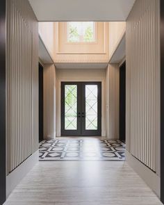 an empty hallway with black and white tile flooring