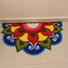 a colorful door mat on the floor in a room with white walls and tile floors