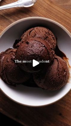 a bowl filled with chocolate ice cream on top of a wooden table