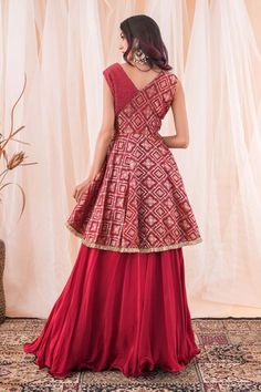 Maroonish red banarasi brocade peplum top with cutdana hand embroidery. Comes with a crepe lehenga. - Aza Fashions Sleeveless Art Silk Dress For Diwali, Navratri Sleeveless Art Silk Dresses, Traditional Peplum Lehenga For Reception, Festive Sleeveless Raw Silk Dress, Festive Red Brocade Dress, Festive Anarkali Style Choli With Peplum, Traditional Sleeveless Sharara With Self Design, Peplum Dress With Zari Work For Festivals, Brocade Dresses For Navratri Reception