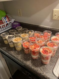 plastic cups filled with food sitting on top of a counter