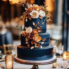 a blue wedding cake with gold flowers on top and candles around the edges is ready to be eaten