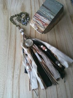 a wooden table topped with lots of different types of beads and chains next to a box