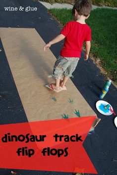 a young boy walking across a sidewalk next to a red and white sign that says dinosaur track flip flops